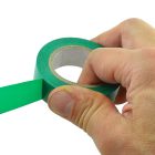 Person Pulling Green Tape From A Roll