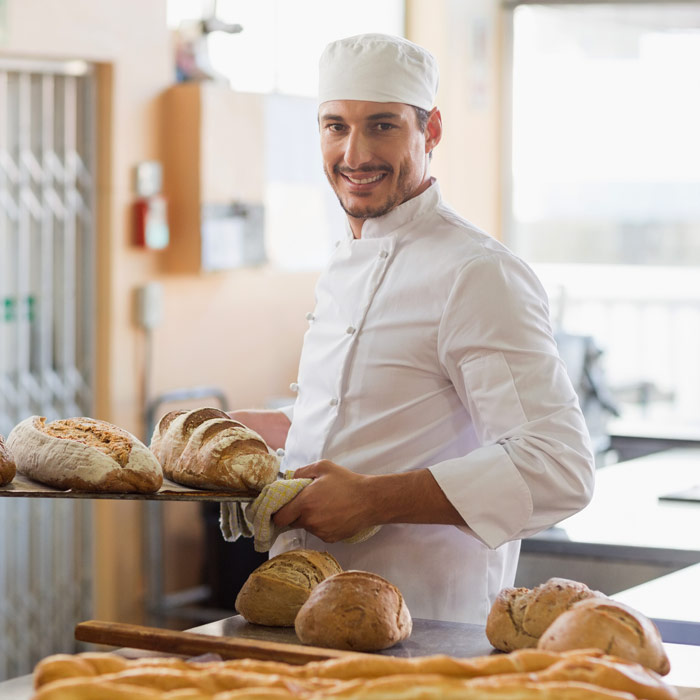 Smiling man baking bread in a restaurant